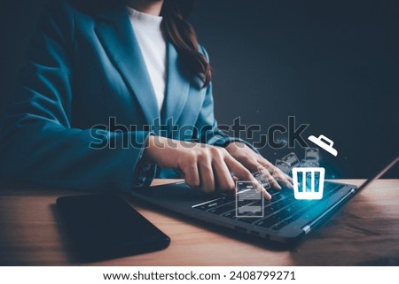 Businesswoman using computer laptop or smartphone delete files  from a computer or from the Internet. Concept of deleting files, contacts, putting in order, cleaning service, trash can and files.
