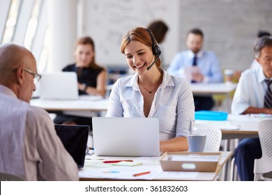 Businesswoman Using Laptop In Customer Service Department