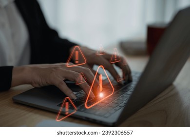 Businesswoman using laptop showing virtual screen icon caution warning triangle and exclamation sign icon Warning of dangerous problems Server error. Virus. Internet network security concept. - Powered by Shutterstock