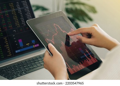 Businesswoman using a tablet computer analyzing stock exchange market crypto trading decreasing chart data fall down loss, desperate about losing money of crisis, recession, inflation.Economic crisis  - Shutterstock ID 2203547965