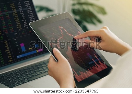 Businesswoman using a tablet computer analyzing stock exchange market crypto trading decreasing chart data fall down loss, desperate about losing money of crisis, recession, inflation.Economic crisis 