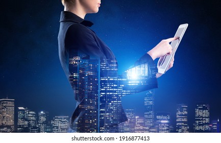Businesswoman using tablet computer. Double exposure concept with night city and woman in business suit. Real estate investment and development. Digital technology in strategy planning and management.