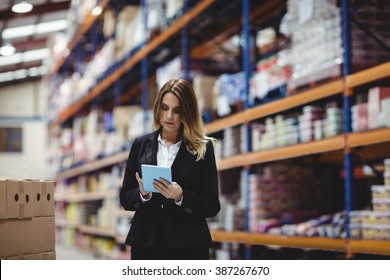 Businesswoman using tablet in warehouse