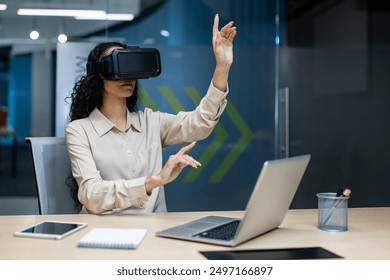 Businesswoman using virtual reality headset in modern office, interacting with digital interface. Young woman immersed in VR technology, exploring virtual workspace, innovation in business - Powered by Shutterstock