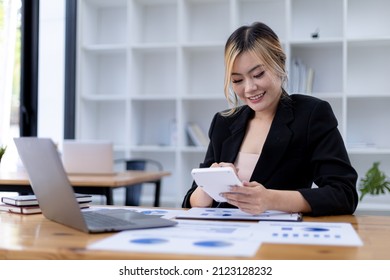 Businesswoman Using A White Calculator, A Financial Businessman Examining The Numerical Data On A Company Financial Document, She Uses A Calculator To Verify The Accuracy Of Numbers.