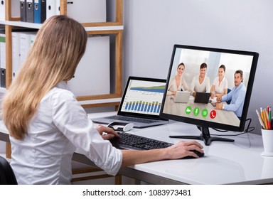 Businesswoman Video Conferencing With Happy Colleagues On Computer In Office