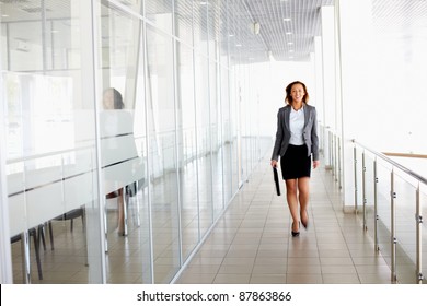 Businesswoman Walking Along The Office Corridor