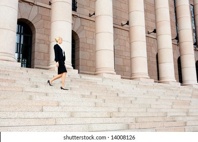 Businesswoman Walking Down The Stairs Of Building