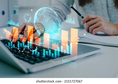 Businesswoman wearing casual wear typing on laptop sitting at office workplace in background. Digital interface with virtual globe, bar diagram, financial graph. Concept of modern technology, trading - Powered by Shutterstock