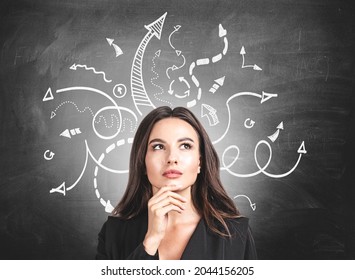 Businesswoman wearing formal suit is standing in front of the chalkboard with sketch with arrows and lines. Concept of imagination and inspiration for creative ideas - Powered by Shutterstock