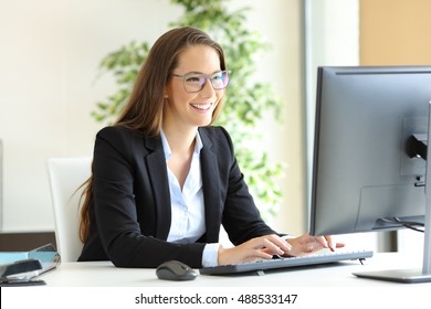 Businesswoman wearing glasses working with a desktop computer at office - Powered by Shutterstock