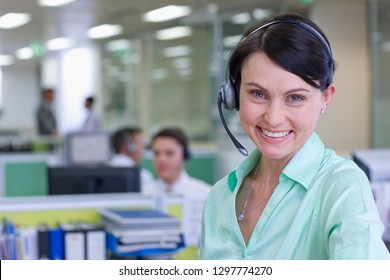 Geschäftsfrau mit Headset in einem Büro für belebte Teleshops, die mit Kamera lächelnd lächelnd
