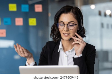 Businesswoman wearing a headset in a video call at a modern office, discussing and explaining ideas. - Powered by Shutterstock