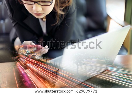 Businesswoman wearing suit, glasses and using smart phone. Double exposure light trail in the city.