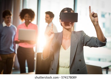 Businesswoman wearing virtual glasses in office - Shutterstock ID 574178089