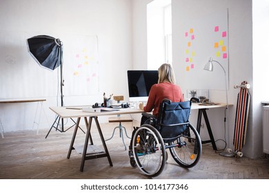 Businesswoman in wheelchair at the desk in her office. - Powered by Shutterstock