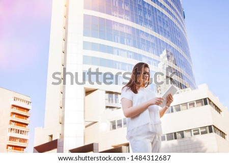 Businesswoman in white jacket with sheet a paper in the city.
