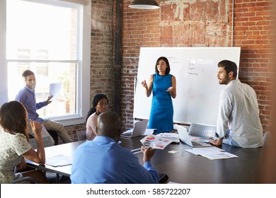 Businesswoman At Whiteboard In Brainstorming Meeting