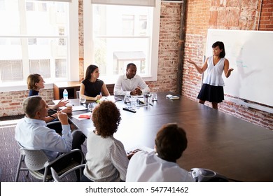 Businesswoman At Whiteboard Giving Presentation In Boardroom - Shutterstock ID 547741462