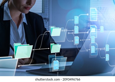 Businesswoman working with computer, look at the screen in office room. Folders with document icons. Cloud storage of business data information. Concept of online database