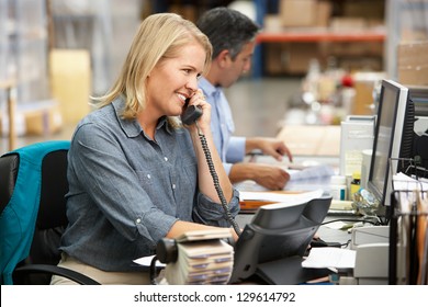 Businesswoman Working At Desk In Warehouse