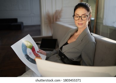 businesswoman working documents. favorite career, life's work. grey stylish suit. glasses smile at the face.