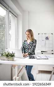 Businesswoman Working At Ergonomic Standing Workstation.