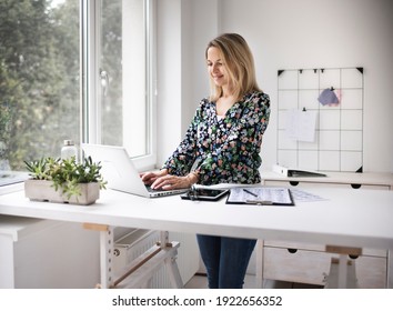 Businesswoman working at ergonomic standing workstation.