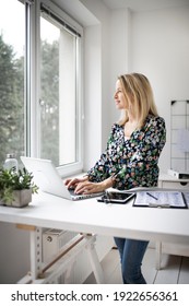 Businesswoman Working At Ergonomic Standing Workstation.