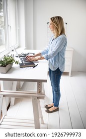 Businesswoman Working At Ergonomic Standing Workstation.