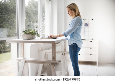 Businesswoman working at ergonomic standing workstation.