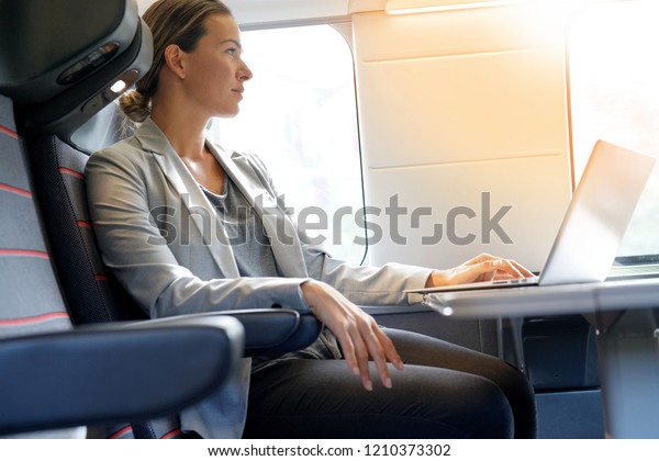 Businesswoman working in first class on a train         
                                                                   
            