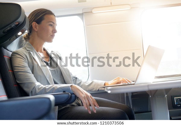 Businesswoman working in first\
class on a train                                                   \
        