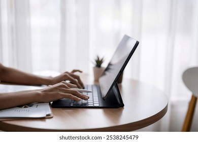 Businesswoman working from home office using tablet and keyboard - Powered by Shutterstock