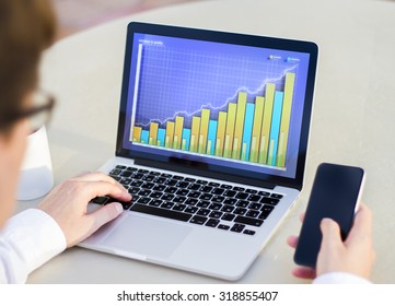 businesswoman working with a laptop on which business graph