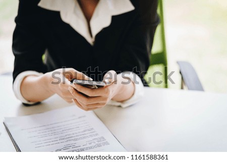 Businesswoman working with a mobile phone above the contract and calculator. Business and partnership concept.