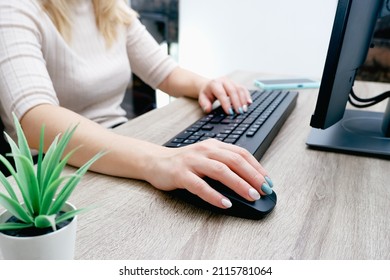 Businesswoman working on a computer from home during pandemic to prevent disease. Remote work. Hands, mouse, keyboard. Cropped shot of woman typing on keyboard and working with desktop computer