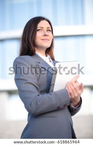 Businesswoman working on digital tablet outdoor over modern building background