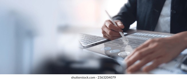Businesswoman working on laptop, using mobile phone at modern office, analyzing business document with financial graph, market report on digital tablet, business data analysis concept