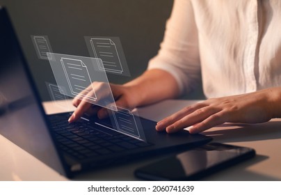 Businesswoman working on   laptop with virtual screen. Process automation to efficiently manage files. Online documentation database and  document management system concept.