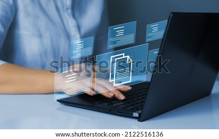 Businesswoman working on   laptop with virtual screen. Online documentation database and  document management system concept.Process automation to efficiently manage files. 