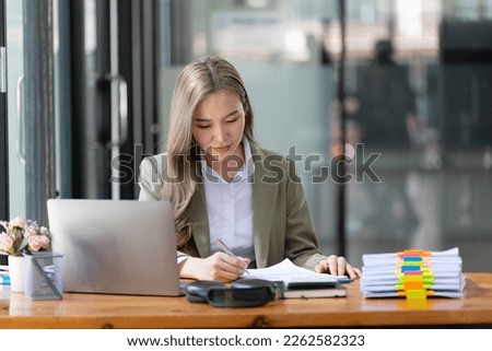 Businesswoman working at the workplace. beautiful Asian woman in a casual suit working reading a book, preparing for a meeting or interview in the office.