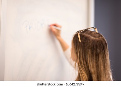 Businesswoman Writing On Whiteboard At Meeting