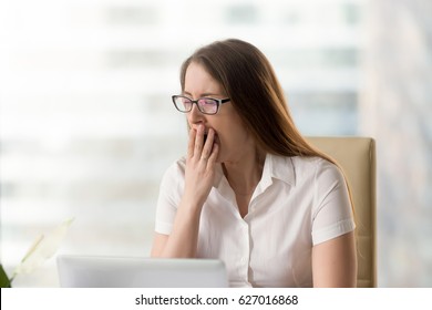 Businesswoman Yawning While Sitting In Office. Woman Feeling Lack Of Sleep During Working Day. Female Employee Bored Monotonous Routine Work. Sleepy Girl Struggles With Drowsiness At The Workplace 