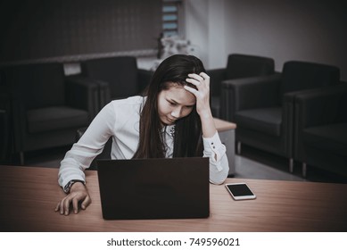 Businesswomanman stress from hard work on the desk at office dark tone,thailand people - Shutterstock ID 749596021