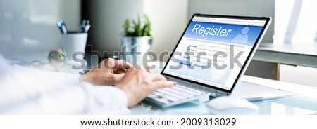 Businesswoman's Hand Filing Online Registration Form On Laptop