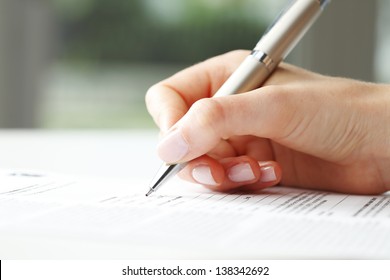Businesswoman's hand with pen completing personal information on a form - Shutterstock ID 138342692