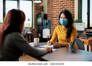 Businesswomen Analyzing Marketing Graphs During Business Partnership Working At Company Project In Startup Office. Entrepreneurs Wearing Medical Face Mask To Prevent Infection With Covid19