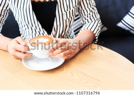 Businesswomen hold cup of coffee.