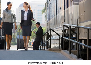 Businesswomen on trip walk along railway platform with train talking